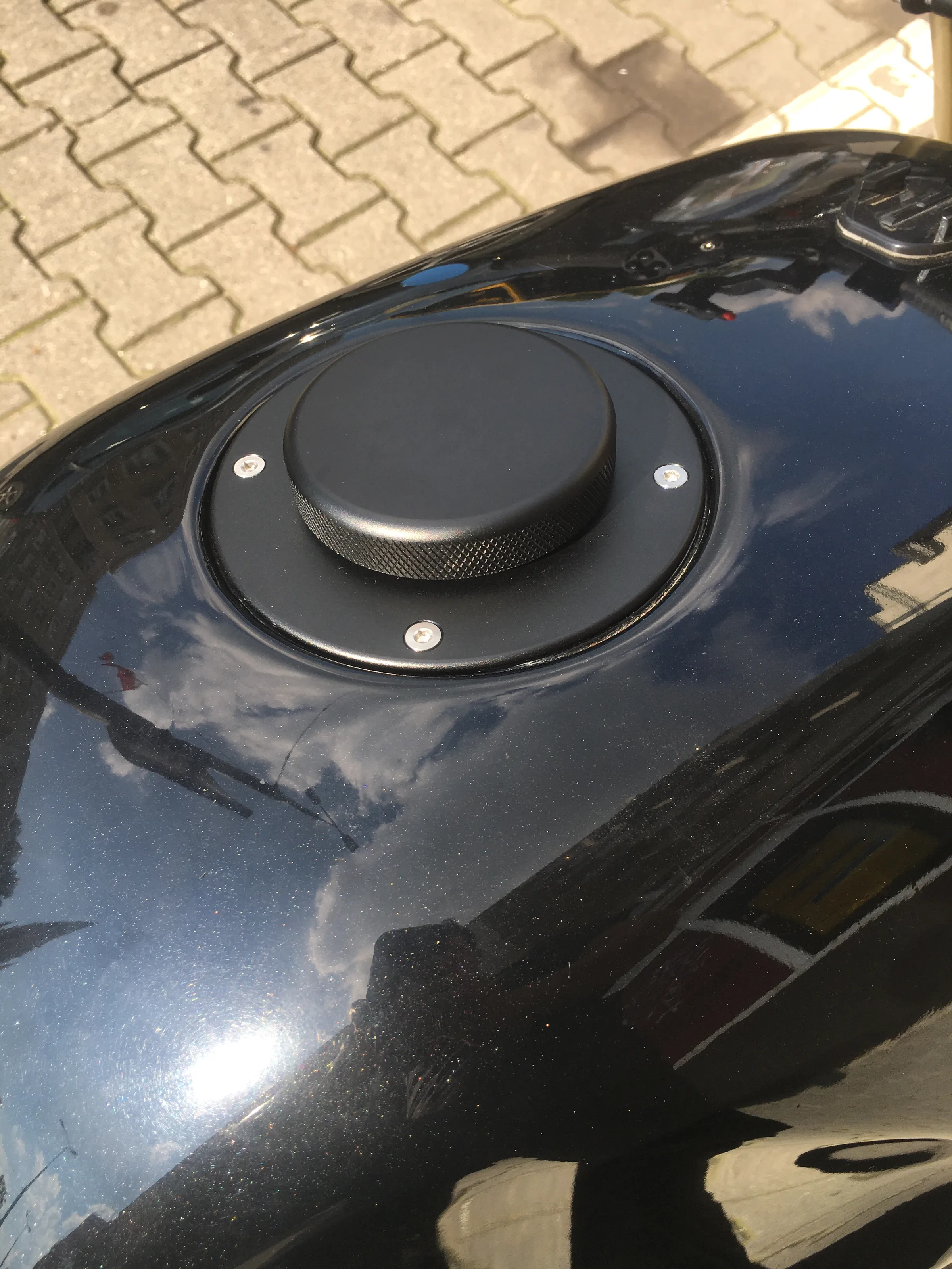 Close-up of the CNC machined fuel cap set into the gloss black tank of the K1100