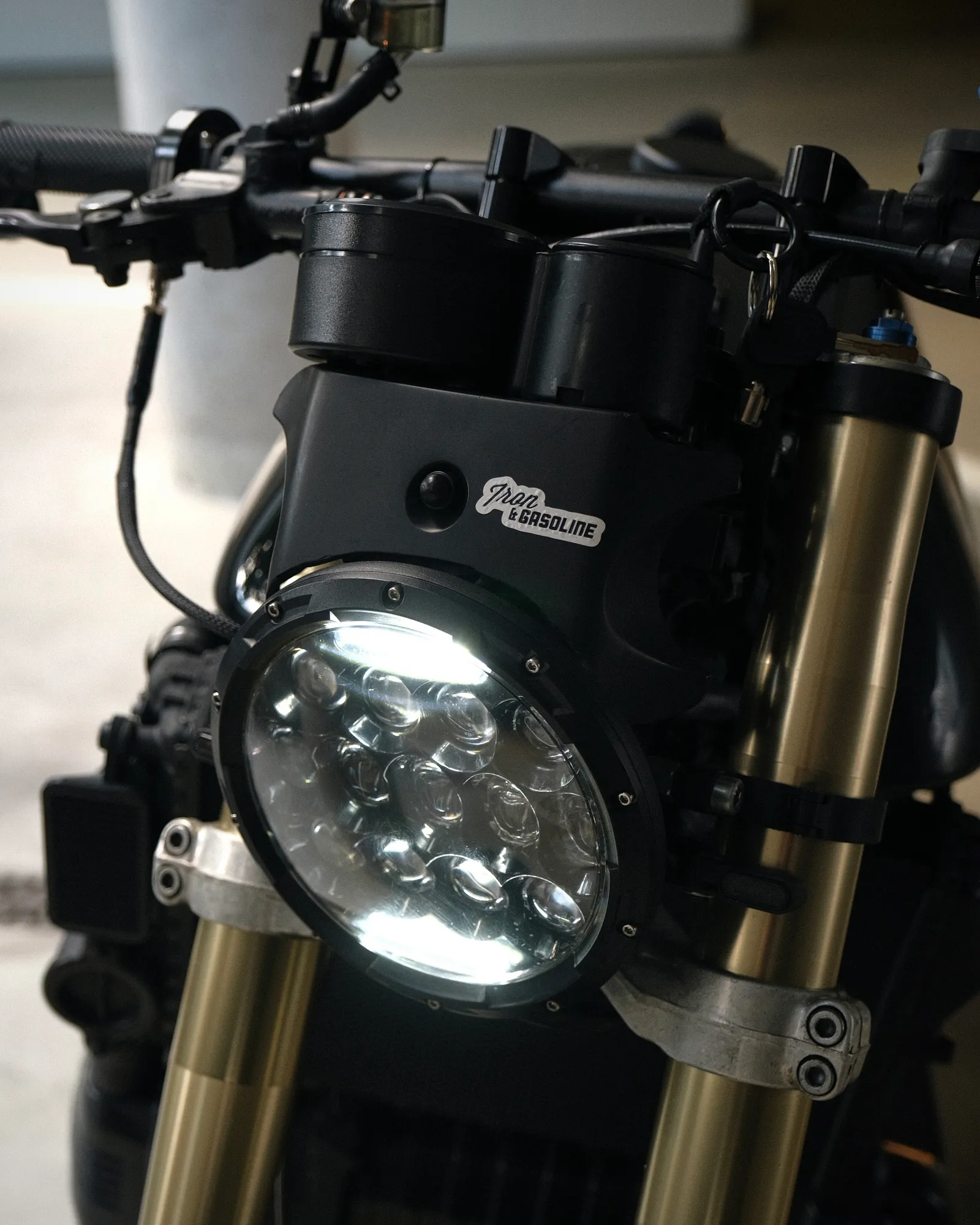 Close-up of the Jeep Wrangler LED headlight with an Iron and Gasoline sticker on the 3D printed bracket