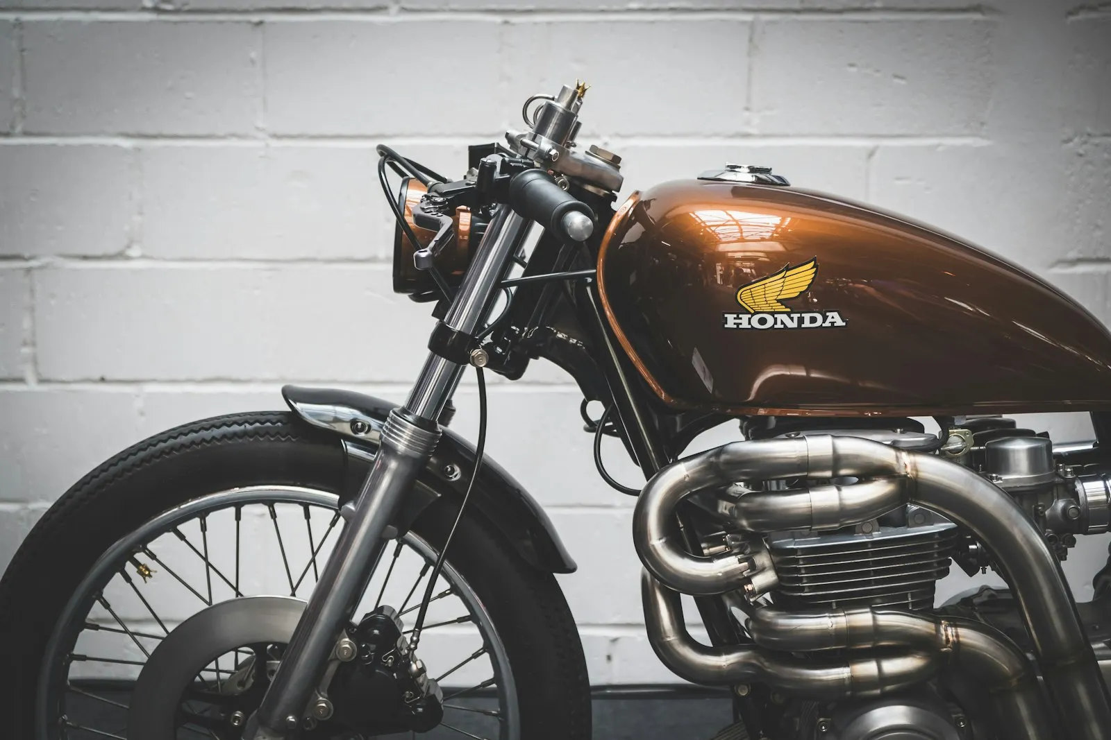 Close-up of a polished Honda fuel tank badge and chrome exhaust